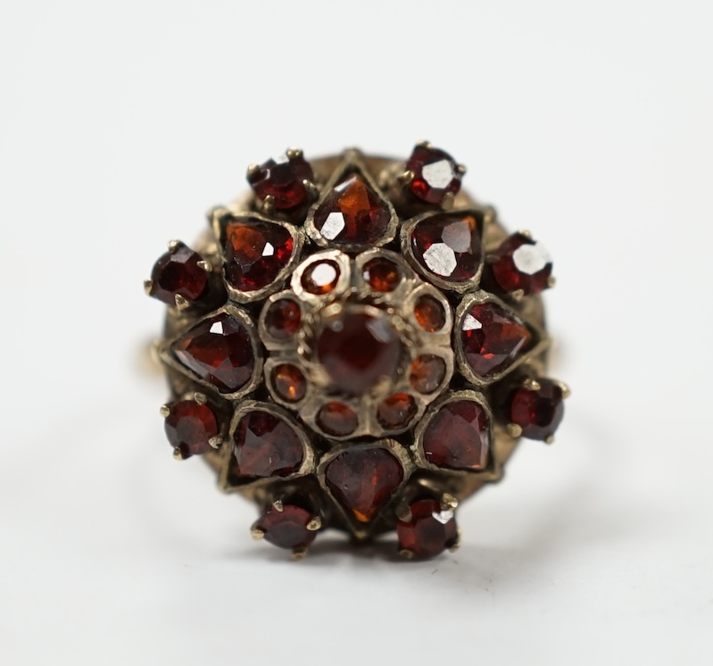 A 14k and garnet cluster set domed dress ring, size M/N, gross weight 3.4 grams. Condition - fair